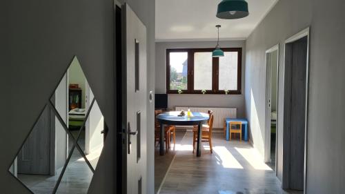 a kitchen and dining room with a table and chairs at Urocze Apartamenty na Wsi in Golędzinów