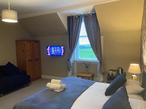 a room with a television and a bed in it at Ernespie House Hotel in Castle Douglas