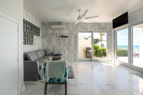 Una sala de estar con un sofá y un ventilador de techo. en SulMare at Sapodilla Bay Luxury villas, en Providenciales