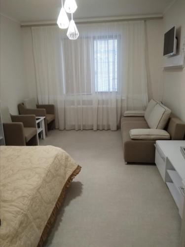 una sala de estar con una cama y un sofá en Modern appartment near Sofievka, en Uman