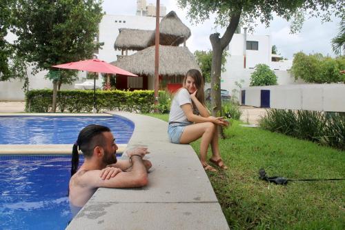 a man and a woman sitting next to a swimming pool at Melaque Paradise in San Patricio Melaque