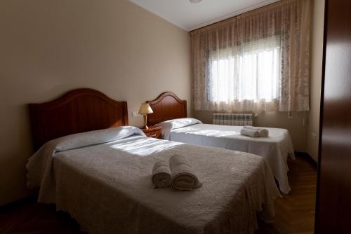 pokój hotelowy z dwoma łóżkami z kapeluszami w obiekcie Playa de Llas w mieście Foz
