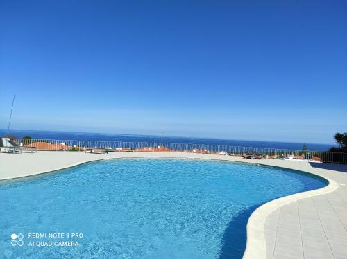 a swimming pool with the ocean in the background at Pearl of Nazaré in Nazaré