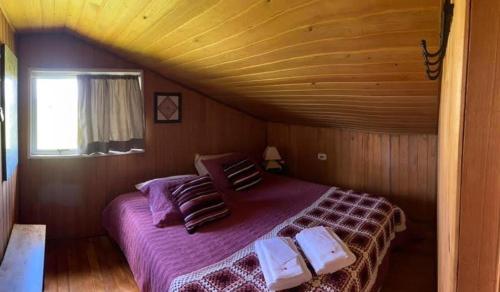 um quarto com uma cama num quarto de madeira em Fazenda Rodeio Bonito em Lages