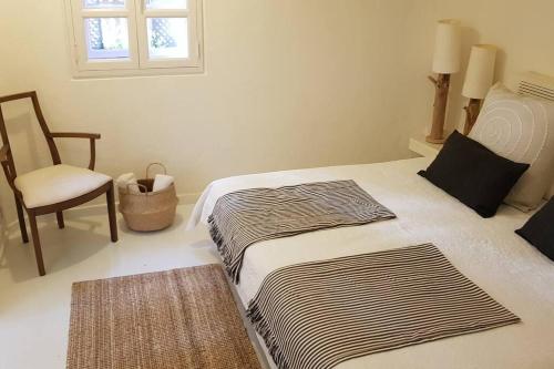 1 dormitorio con 1 cama con silla y ventana en DESIGNER HOME WITH INCREDIBLE VIEWS ON TOP OF THE BEACH, en Playa del Águila