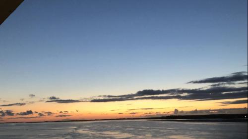 uma imagem de um pôr-do-sol sobre a água em Gwêl y Fenai em Y Felinheli