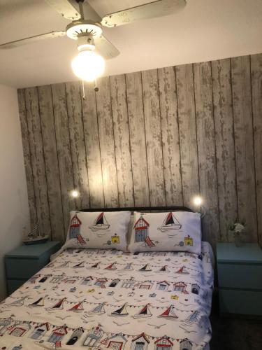 um quarto com uma cama e uma parede de madeira em Gwêl y Fenai em Y Felinheli