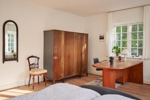 una oficina con escritorio de madera y armario de madera en Enkesædet Bollegård en Ørsted