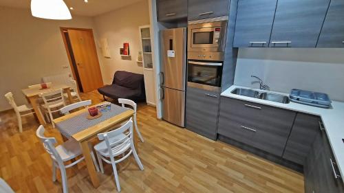 a kitchen and dining room with a table and a kitchen and a dining room at L'Astrolabi in Ripoll