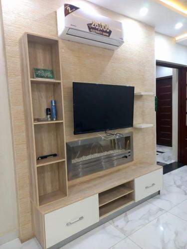 a large wooden entertainment center with a flat screen tv at Bahria V&A Phase-2 in Rawalpindi