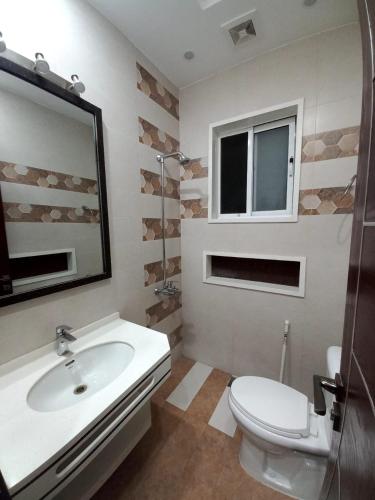 a bathroom with a sink and a toilet and a mirror at Bahria V&A Phase-2 in Rawalpindi