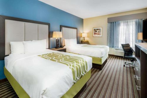 a hotel room with two beds and a desk at La Quinta Inn & Suites by Wyndham Broussard - Lafayette Area in Broussard