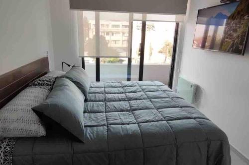 uma cama grande num quarto com uma janela grande em Edificio Curitiba, Apartamento nuevo y céntrico 1B 1D em Temuco