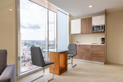 a kitchen with a table and chairs and a large window at The View Hotel by Covalia in San Luis Potosí