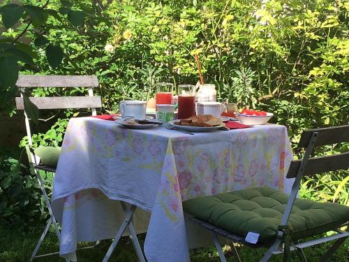 een tafel met eten erop met twee stoelen bij Bévau - B&B bio in Trampot