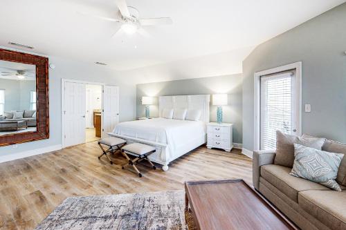een slaapkamer met een wit bed en een bank bij 2 Carats East in Gulf Shores