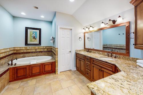 een badkamer met een bad en een grote spiegel bij 2 Carats East in Gulf Shores