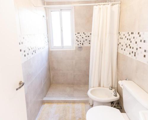 biała łazienka z toaletą i prysznicem w obiekcie casa quinta, alquiler temporario w mieście Toay