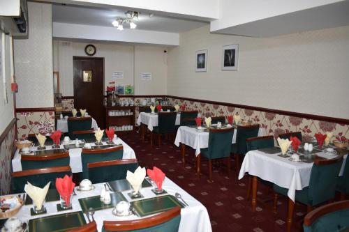 a dining room with tables and chairs with red napkins at Lyndhurst Hotel in Blackpool