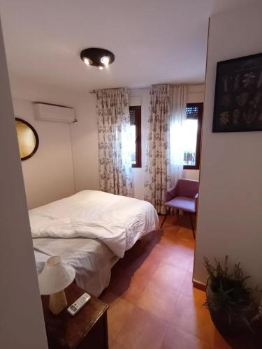 a small bedroom with a bed and a chair at La Tijera in Candeleda