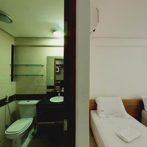 a bathroom with a bed and a toilet and a sink at Flat Mar do Cabo Branco Residence in João Pessoa