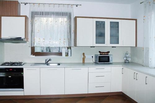 a kitchen with white cabinets and a microwave at Holiday Home in Kretowiny near Lake in Kretowiny