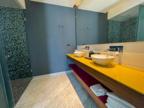 a bathroom with two sinks and a shower at Hotel Belo Grand Morelia in Morelia