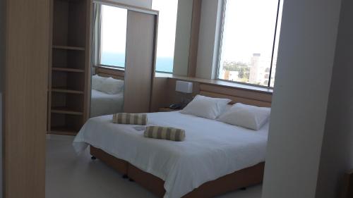 a bedroom with a large bed with two pillows on it at Vrissaki Beach Hotel in Protaras