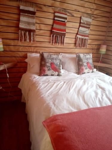 a bedroom with a bed with pillows and birds on it at Pupuya Vista Hermosa in Navidad