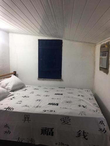 a bedroom with a bed with a blue window at Casa Areiasardin in Barrinha