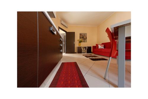 a living room with a red chair and a red rug at 4Canti Case Vacanze in Castellammare del Golfo
