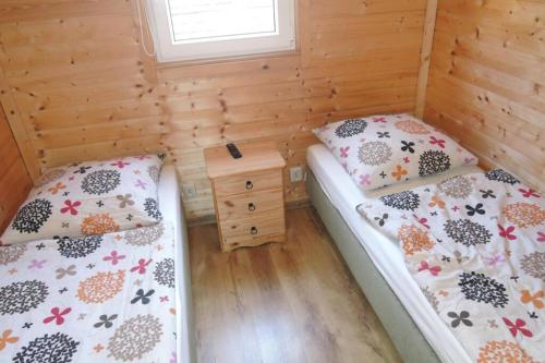 two beds in a room with wooden walls at Holiday complex with the pool and volleyball in Miedzyzdroje in Międzyzdroje