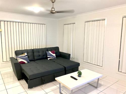 a living room with a couch and a coffee table at Modern 4BR close to the Airport- Whole house in Gladstone