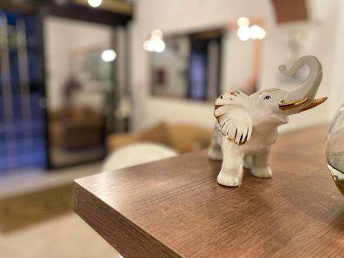 a toy elephant sitting on a table next to a wine glass at Hotel Eterna Primavera in Medellín