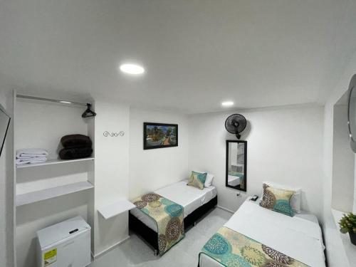 a room with two beds and a bed and a couch at Hotel Eterna Primavera in Medellín