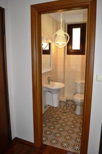 a bathroom with a sink and a toilet and a chandelier at Evmorfes Villas in Poligiros