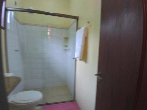 a bathroom with a toilet and a shower and a door at Pousada da Terra Paraty in Paraty