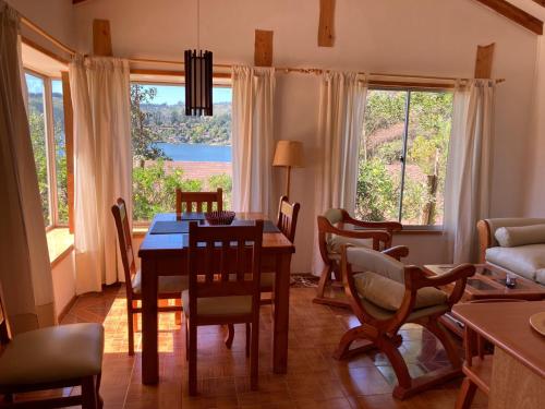 a dining room with a table and chairs and a couch at Cabañas Parador del Aguila - Lago Vichuquén in Vichuquén