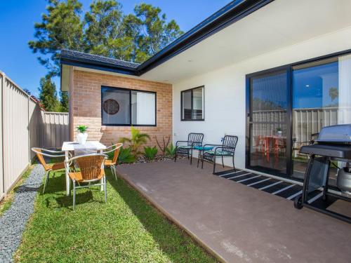 a patio with chairs and a table and a grill at Villa Mare I 4 Mins to Beach in Culburra Beach