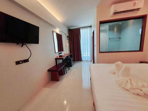 um quarto de hotel com uma grande televisão de ecrã plano na parede em SUhotel Suratthani em Surat Thani