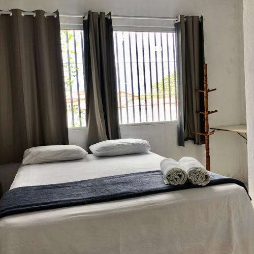 a bedroom with a bed with two towels on it at Pousada Center in Barreirinhas