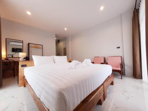 a bedroom with a large bed with white sheets at SUhotel Suratthani in Surat Thani