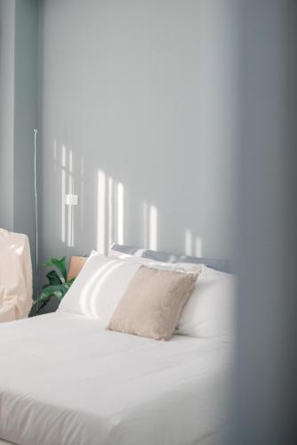 台東市にあるTaitung mini trip hostelの白いベッド(枕付)