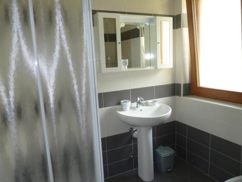 W łazience znajduje się umywalka oraz prysznic z lustrem. w obiekcie Casa Marisa w mieście Malcesine