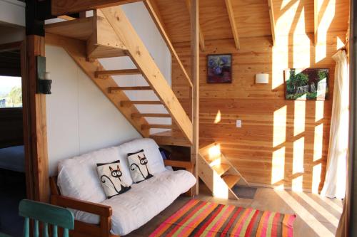 a small room with a couch in a tiny house at Cabaña Los Carpinteros, Conguillïo, Sector Los Paraguas in Vilcún