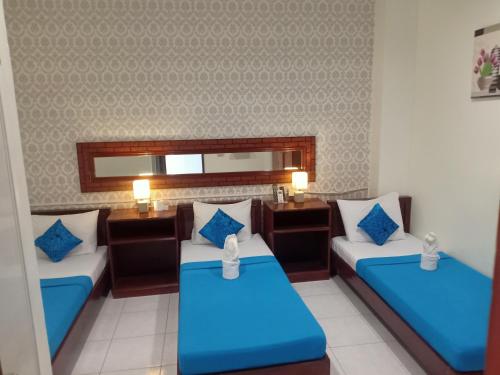 a hotel room with two beds and a mirror at Davao Hub Bed and Breakfast in Davao City