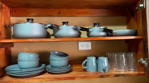a shelf with pots and pans and plates on it at La Serrania B&B in Boquete