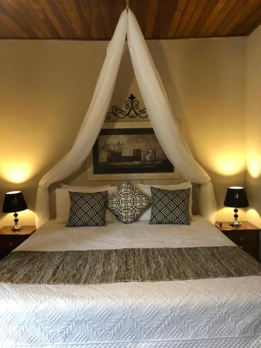 1 dormitorio con 1 cama blanca con dosel en Pousada Casa Grande en Pirenópolis