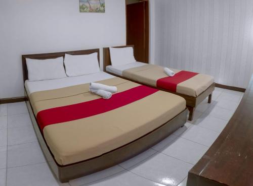 two beds sitting next to each other in a room at Davao Hub Bed and Breakfast in Davao City