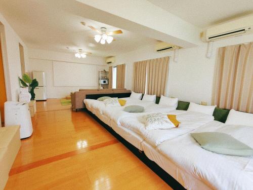 a large room with white beds in it at River Sky Hakata in Fukuoka